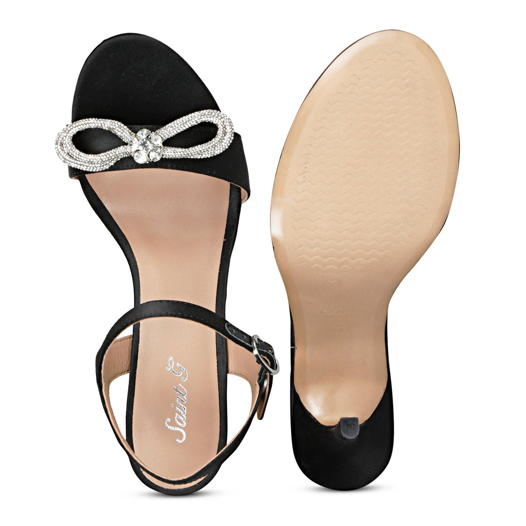 Black leather-satin stilettos by Saint Hayden, adorned with a crystal bow for a chic and stylish vibe.